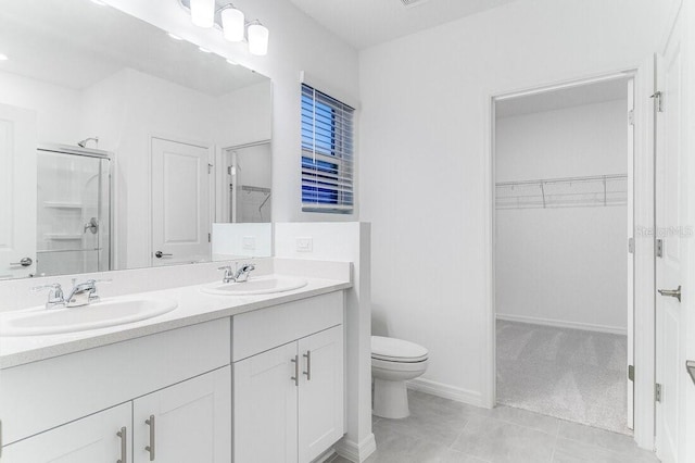 bathroom with vanity, tile patterned flooring, a shower with shower door, and toilet