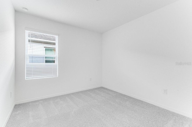 unfurnished room with light carpet