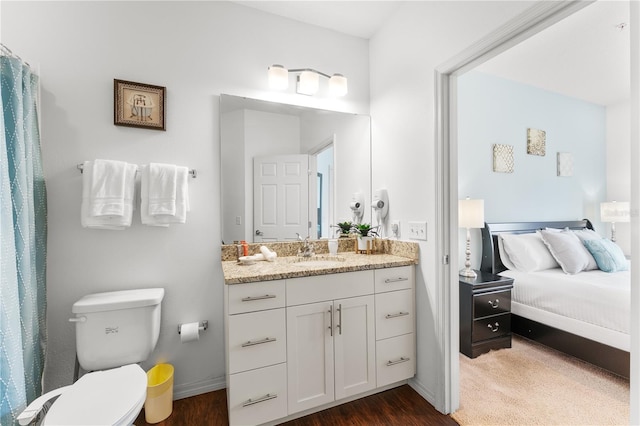 bathroom with wood-type flooring, vanity, and toilet