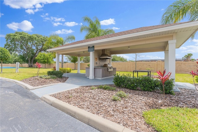 view of community featuring area for grilling and a lawn