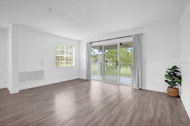 unfurnished room with wood-type flooring and a textured ceiling