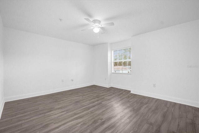 spare room with dark wood-type flooring and ceiling fan