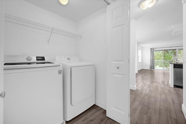 laundry room with washing machine and clothes dryer and dark hardwood / wood-style floors