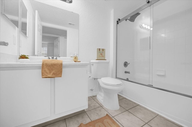 full bathroom featuring toilet, tile patterned flooring, vanity, and combined bath / shower with glass door