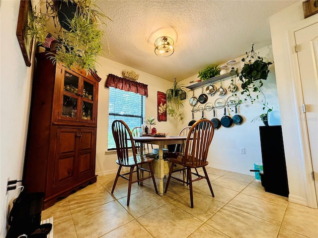 dining area featuring light tile patterned flooring and a textured ceiling