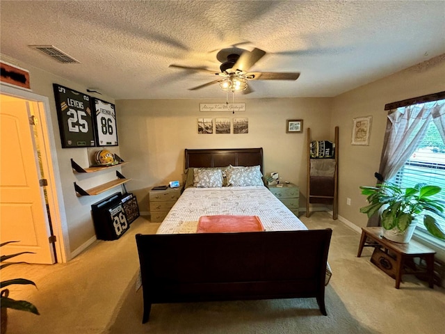 carpeted bedroom with ceiling fan and a textured ceiling