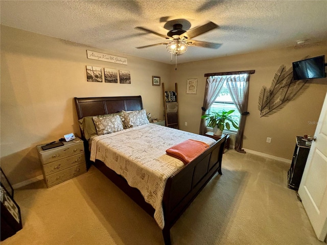 carpeted bedroom featuring ceiling fan and a textured ceiling