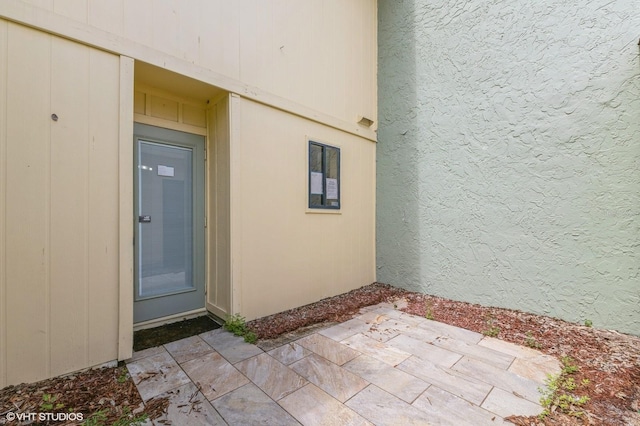 view of exterior entry featuring a patio area