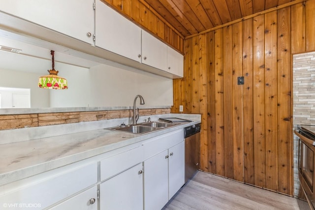 kitchen featuring sink, white cabinets, light hardwood / wood-style flooring, and decorative light fixtures