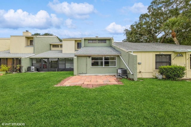 rear view of house with a patio, cooling unit, and a yard