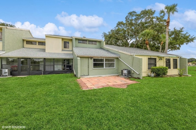 rear view of house featuring central air condition unit, a patio, and a lawn