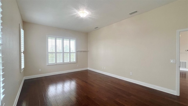 spare room with dark hardwood / wood-style floors