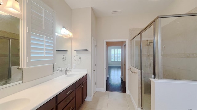 bathroom with tile patterned flooring, vanity, and a shower with door