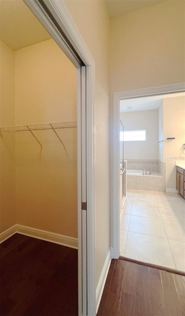 bathroom featuring tiled bath and hardwood / wood-style flooring