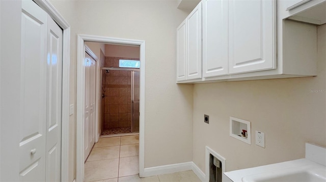 laundry area with hookup for an electric dryer, washer hookup, cabinets, and light tile patterned floors