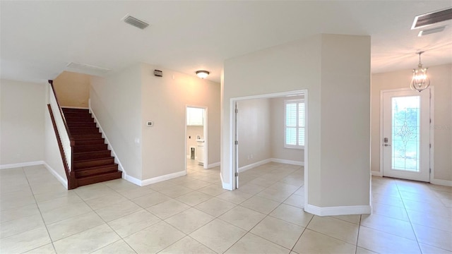 interior space featuring an inviting chandelier, light tile patterned floors, and plenty of natural light