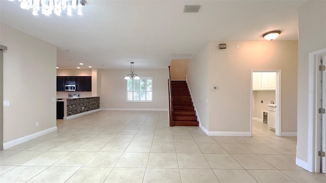 unfurnished living room featuring light tile patterned floors and a notable chandelier