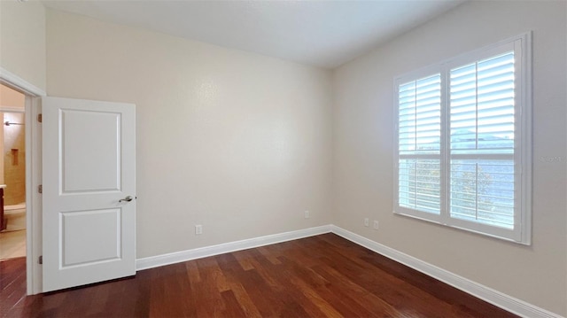 spare room with dark hardwood / wood-style floors