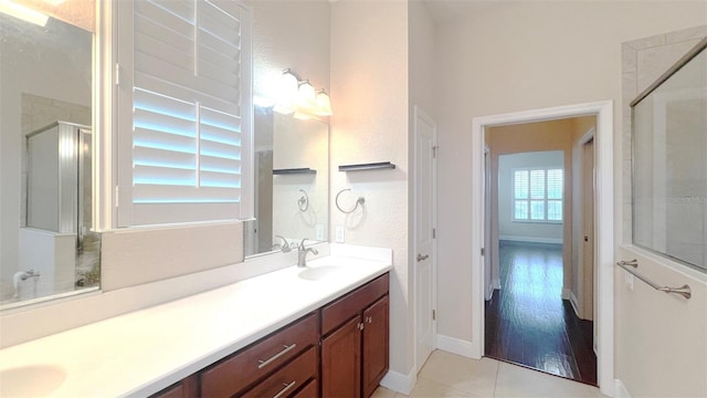 bathroom featuring wood-type flooring, vanity, and a shower with shower door