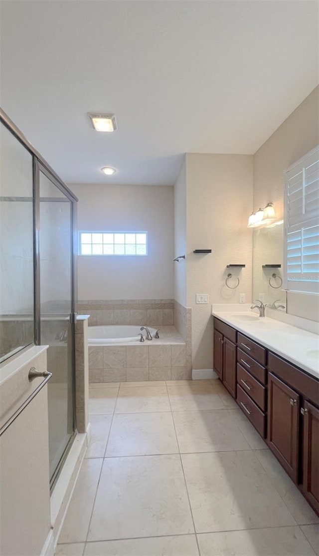 bathroom with shower with separate bathtub, vanity, and tile patterned flooring