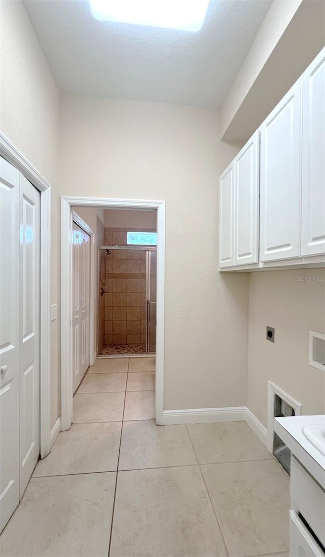 laundry area featuring hookup for a washing machine, cabinets, light tile patterned flooring, and hookup for an electric dryer