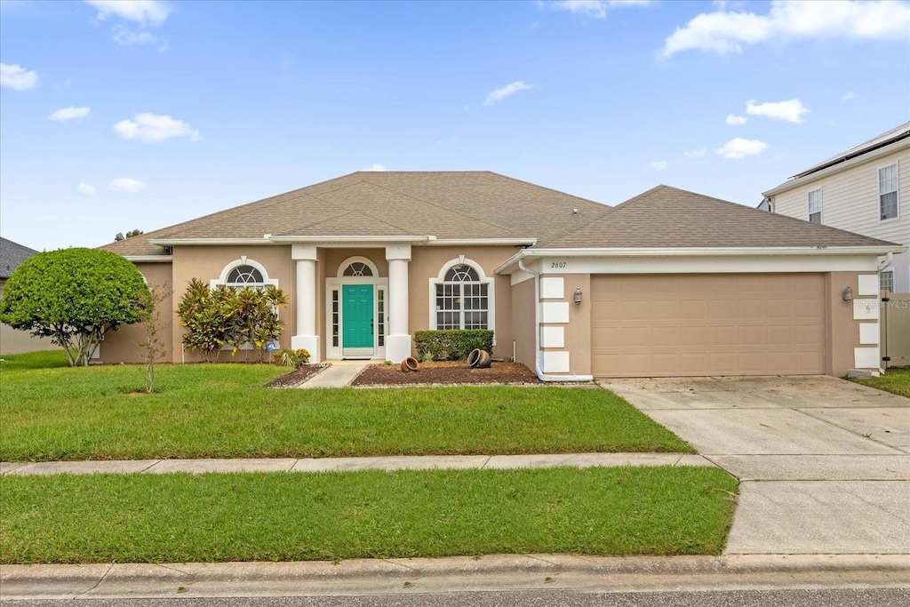 view of front of property with a front yard and a garage