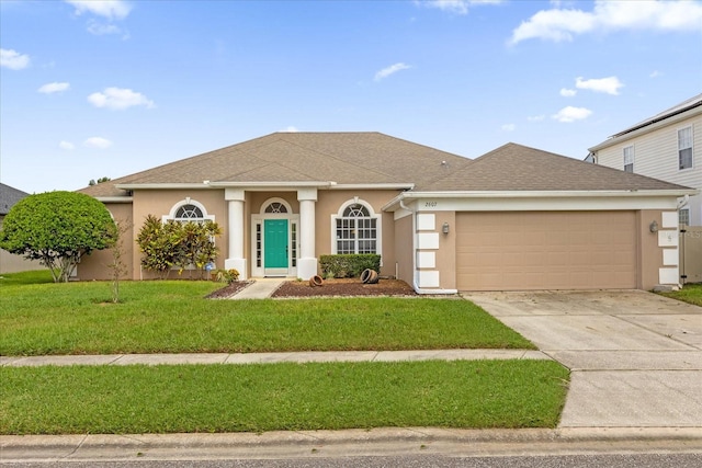 view of front of property with a front yard and a garage