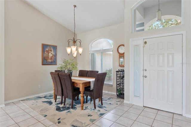 tiled dining area featuring high vaulted ceiling and a chandelier