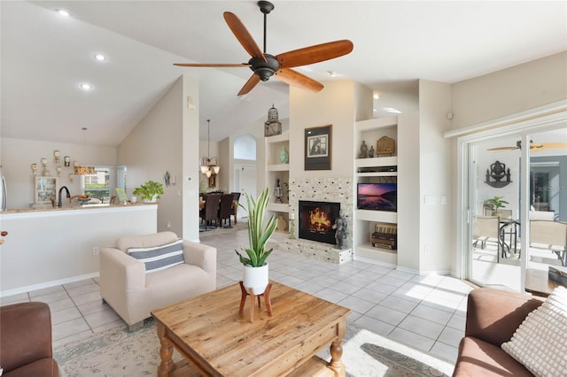 living room with built in shelves, high vaulted ceiling, ceiling fan with notable chandelier, and light tile patterned floors