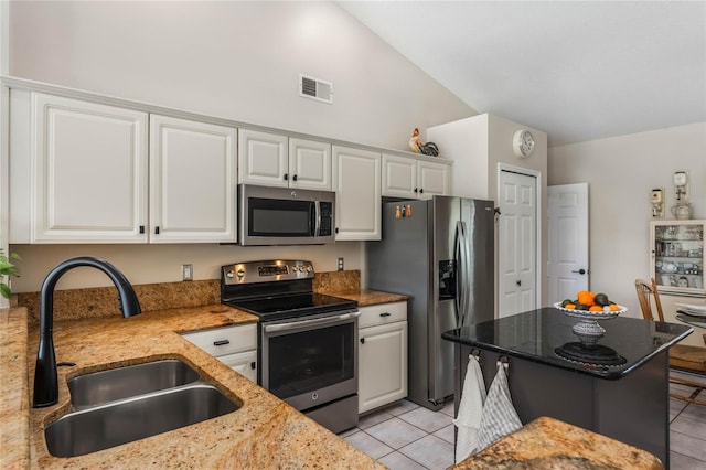 kitchen with light tile patterned flooring, appliances with stainless steel finishes, sink, white cabinets, and light stone counters