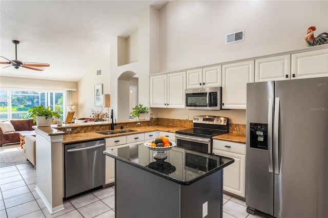 kitchen featuring a center island, sink, kitchen peninsula, and appliances with stainless steel finishes