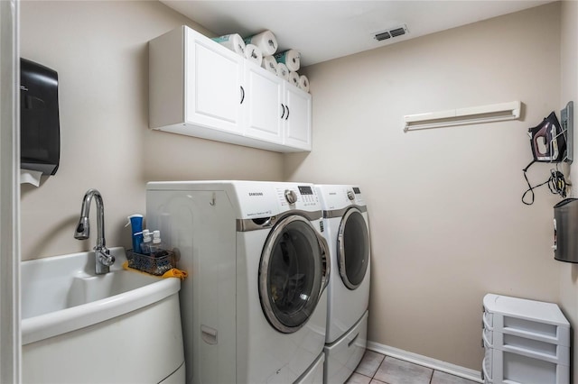 laundry room with sink, washer and clothes dryer, cabinets, and light tile patterned flooring