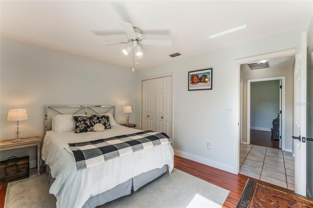 bedroom with ceiling fan, light hardwood / wood-style floors, and a closet