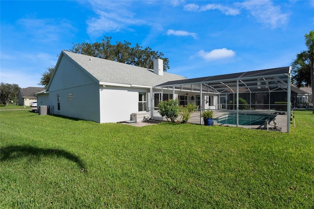 back of house with a patio, a yard, cooling unit, and glass enclosure