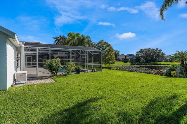 view of yard featuring a water view and glass enclosure