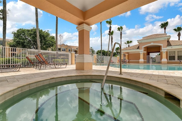 view of swimming pool featuring a hot tub and a patio area