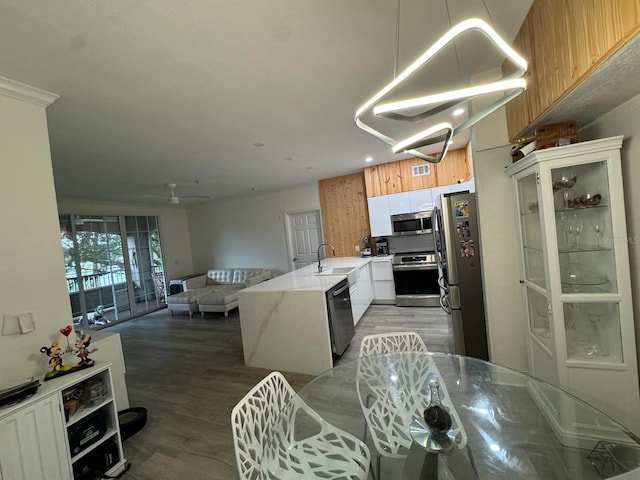 kitchen with ceiling fan, sink, white cabinetry, appliances with stainless steel finishes, and light wood-type flooring