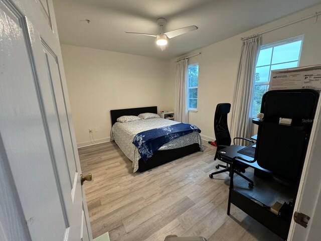 bedroom with light hardwood / wood-style floors, multiple windows, and ceiling fan