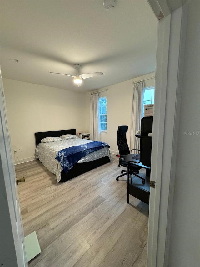 bedroom with light hardwood / wood-style flooring and ceiling fan