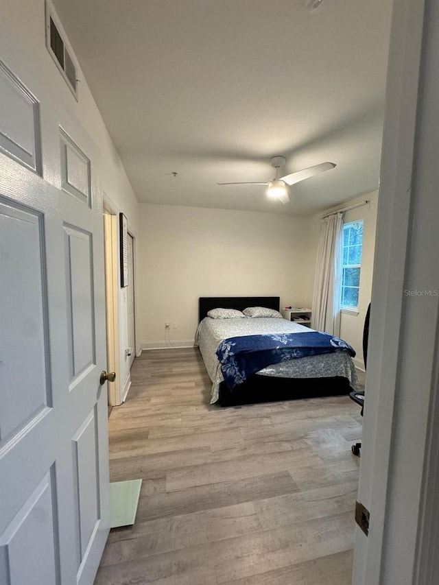 bedroom with ceiling fan and light hardwood / wood-style floors