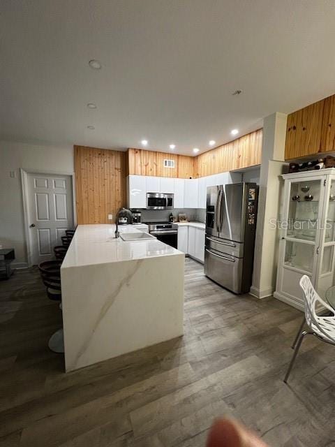 kitchen featuring white cabinets, stainless steel appliances, sink, and light hardwood / wood-style flooring