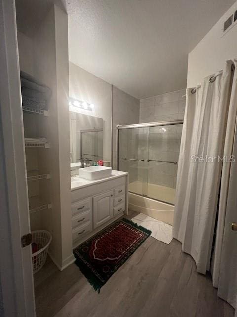 bathroom featuring hardwood / wood-style flooring, shower / tub combo with curtain, and vanity