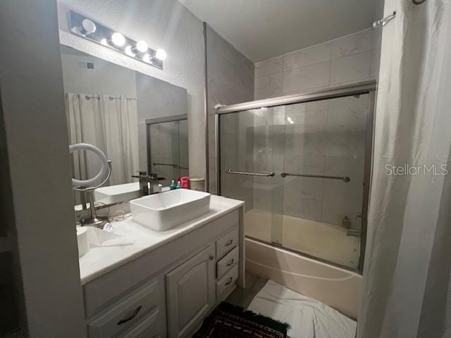 bathroom featuring enclosed tub / shower combo and vanity