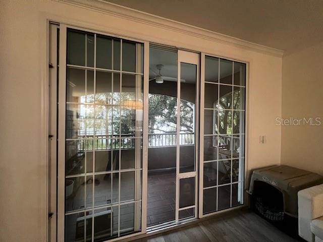 doorway to outside featuring ceiling fan, crown molding, and dark hardwood / wood-style flooring