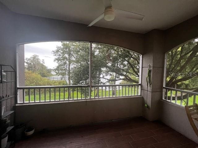 unfurnished sunroom with ceiling fan