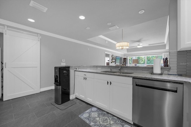 kitchen with light stone counters, backsplash, white cabinetry, dishwasher, and a barn door