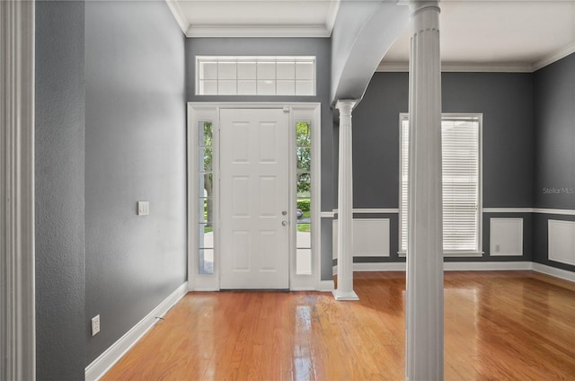 entryway featuring light hardwood / wood-style floors, crown molding, and decorative columns