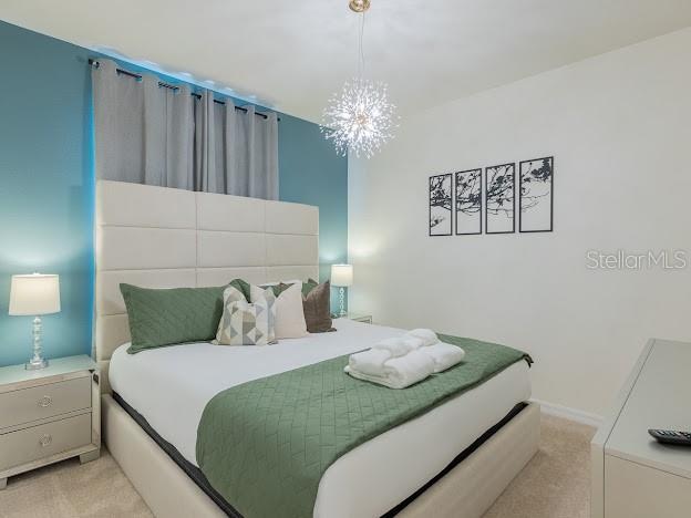 carpeted bedroom featuring a chandelier