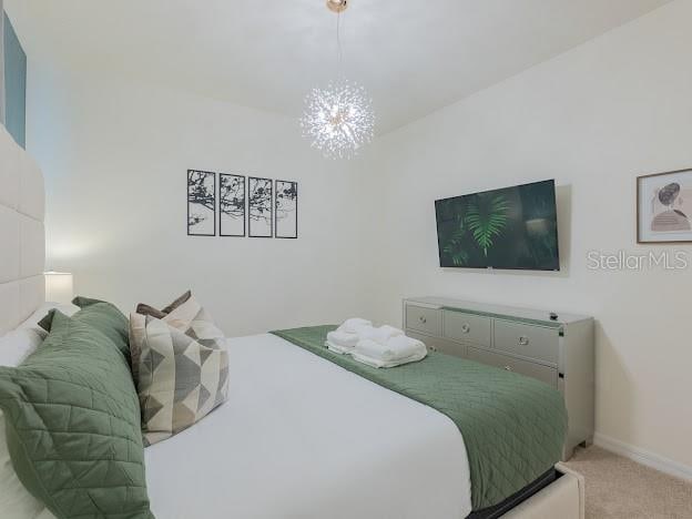 bedroom featuring a chandelier and light carpet