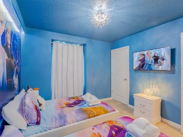 bedroom with a chandelier and a textured ceiling